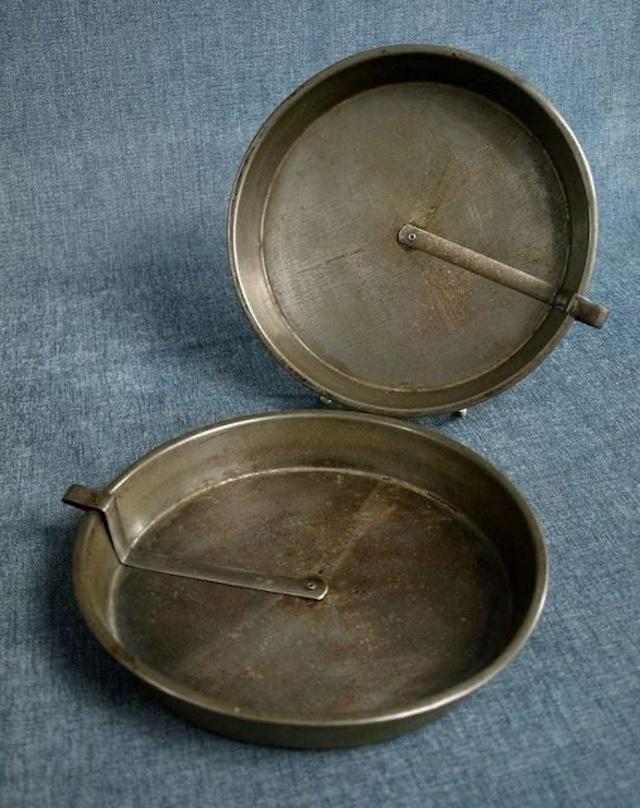 A close-up of the vintage slider cake pan, showcasing its unique sliding mechanism that was essential for perfectly releasing cakes without damaging them